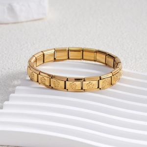 Detailed close-up of golden stainless steel Italian charm bracelet with floral engravings