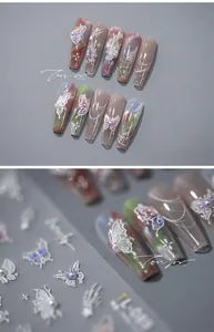 Macro detail of 5D butterfly nail art stickers and long coffin nails with pearls