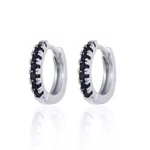 Close-up of silver huggie hoop earrings with micro-paved black stones and mirror reflection