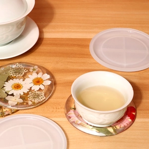 DIY round silicone resin mold with floral coaster featuring embedded dried daisies
