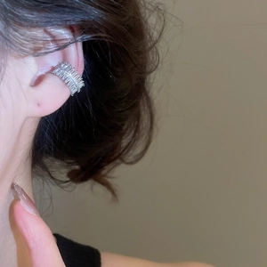 Close-up of double-row baguette zircon ear cuff in silver finish on model ear