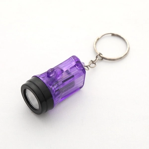 Macro shot of purple translucent mini LED flashlight keychain with silver metal ring