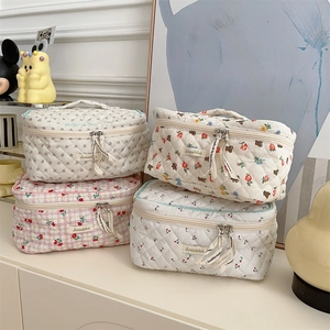 Close-up of quilted cotton cosmetic bags featuring floral, plaid, and cherry patterns