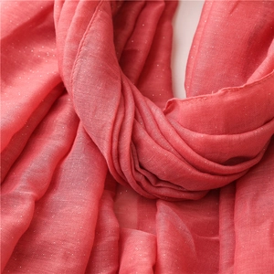 Detail of coral pink scarf fabric with subtle gold thread and delicate pleats texture