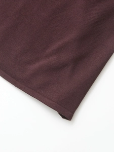 Close-up of deep burgundy knit fabric showing detailed stitching and premium texture