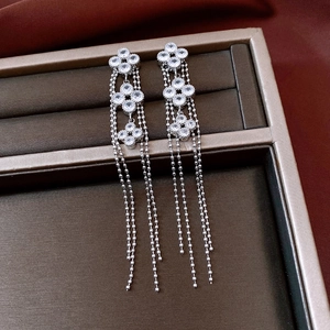 Detail of silver clover earrings with long beaded tassels and sparkling crystals