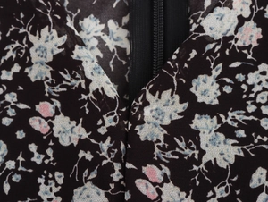 Detailed macro view of floral fabric pattern with high-quality back zipper stitching