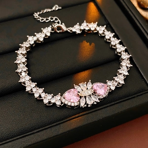 Close-up of silver bracelet featuring pink heart gems and sparkling zircon flowers