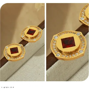 Makroansicht von Vintage-Goldohrsteckern mit rotem Zirkon und Mikro-Diamanten-Besatz