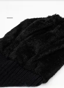 Close-up of black knitted beanie featuring thick fleece lining and ribbed outer texture