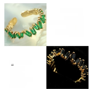 Macro detail of 18K gold plated copper ring featuring green and black zircon stones