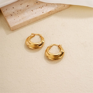 Chic geometric thick gold hoop earrings for women presented on a minimalist stone base