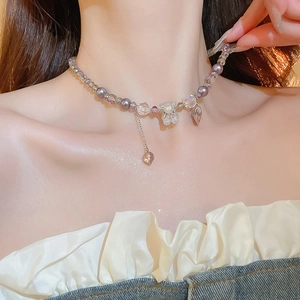 Detail of sweet purple crystal bear pendant with beaded tassel necklace on a model