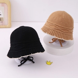 Detail of brown and black knit fisherman hats with scalloped edges and tie straps