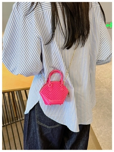 Detailed view of mini rose red shell-shaped jelly bag with quilted texture and chain strap