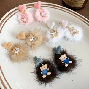 Close-up of fluffy plush bear earrings in pink, white, khaki and dark brown colors