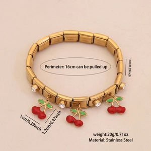 Detail of gold stainless steel stretch bracelet with red cherry charm and white rhinestones