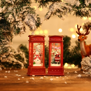 Close-up of lighted Christmas telephone booth ornaments with Santa and snowman figurines