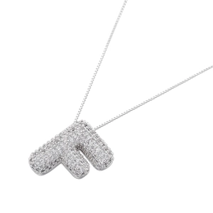 Macro shot of silver letter F pendant featuring sparkling zircon micro-paving on fine chain