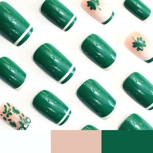 Green and pink press-on nails with shamrock patterns, rhinestones and french stripe design