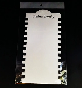 Close-up of white multi-slot jewelry display cards with clear OPP self-sealing bags