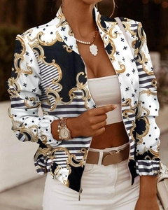 Detailed view of women's bomber jacket with ornate gold Baroque patterns and stripes