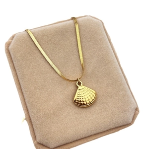Golden seashell pendant necklace with a sleek snake chain in minimalist stainless steel style