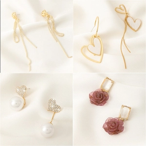 Collage of four earrings featuring gold tassels, pearls, and purple rose designs