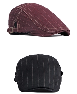 Détail de casquettes gavroche à rayures bordeaux et noires avec boucles réglables