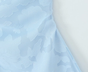 Gros plan sur un tissu en dentelle bleu clair avec texture florale 3D jacquard