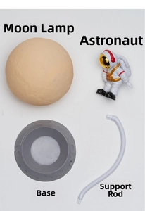 Exploded view of astronaut moon lamp parts including lunar sphere, figure, and crater base