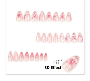 Detail of 3D embossed flowers, pearls, and rhinestones on pink gradient almond nails
