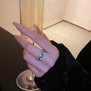 Vue détaillée d'une bague plaquée or avec alternance de zircons verts et blancs brillants