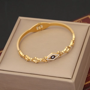Macro view of golden evil eye bangle with sparkling rhinestones on jewelry box