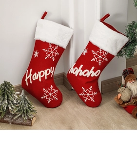 Detail of red Christmas stockings with white snowflake patterns and Happy Hohoho embroidery