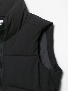 Detail of black quilted puffer vest showing the stand collar and smooth zipper closure