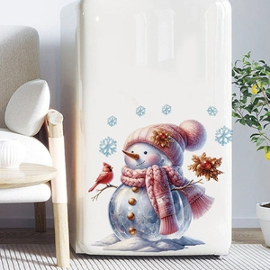 Close-up of cute snowman stickers with pink scarf on a white vintage refrigerator