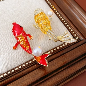 Detailed view of high-quality carp brooches with enamel, zircons, and white pearls