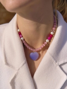 Close-up of beaded necklace with pink cat eye stones, pearls, and purple heart pendant