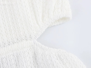 Detail of white mesh knit fabric with intricate hollow-out texture for beach vacation dress