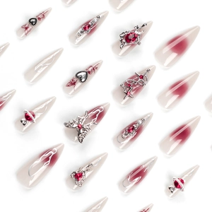 Faux ongles stiletto avec dégradé rouge et charmes métalliques 3D argentés chic