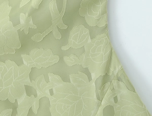 Detailaufnahme von minzgrünem Jacquard-Stoff mit edlen floralen Rosen-Texturmustern