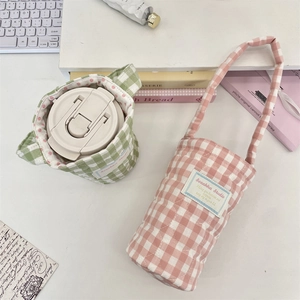 Quilted plaid water bottle carrier with adjustable shoulder strap and polka dot lining