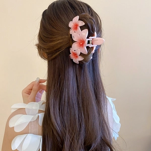 Pink gradient acrylic flower hair claw clip for women in an elegant updo hairstyle