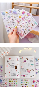 Close-up of translucent birthday theme stickers with balloons and cakes for scrapbooking