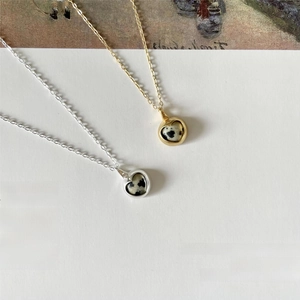 Minimalist 925 silver heart necklace with spotted zebra stone on artistic background