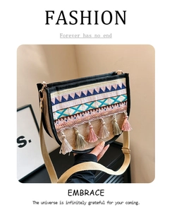 Detailed close-up of ethnic woven crossbody bag with geometric embroidery and tassels