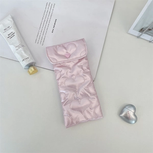 Detailed view of pink quilted PU heart-pattern glasses pouch with satin finish button