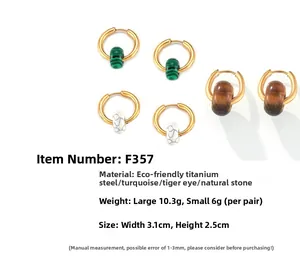 Detail of titanium steel hoop earrings featuring natural tiger eye and malachite beads