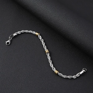 Detalle de una pulsera de cuerda de 5 mm de acero inoxidable con cuentas doradas